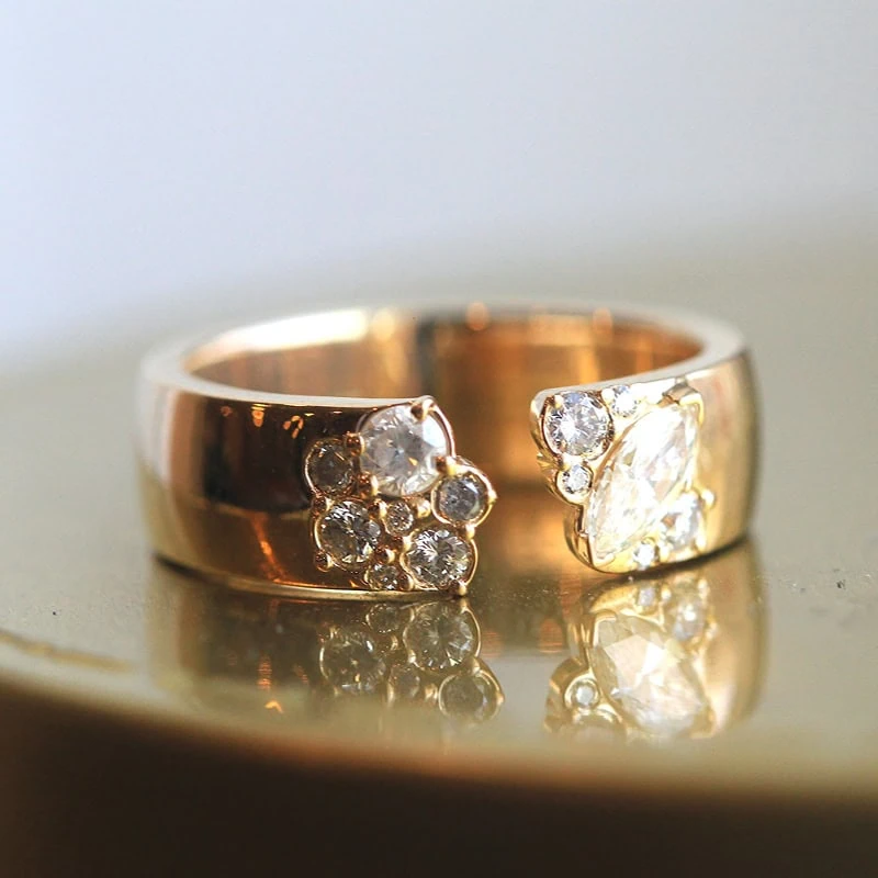 Wide gold band with asymmetrical diamond cluster design