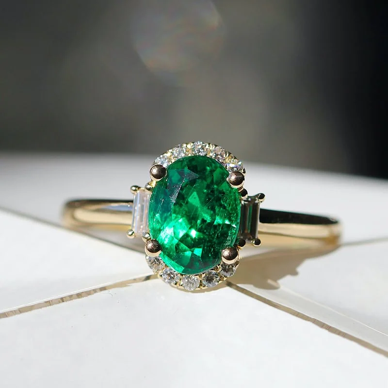 Emerald and diamond ring with an oval emerald center stone