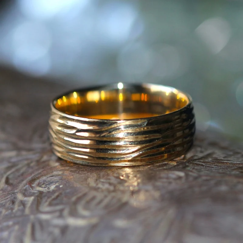 Textured gold wedding band with layered wave pattern
