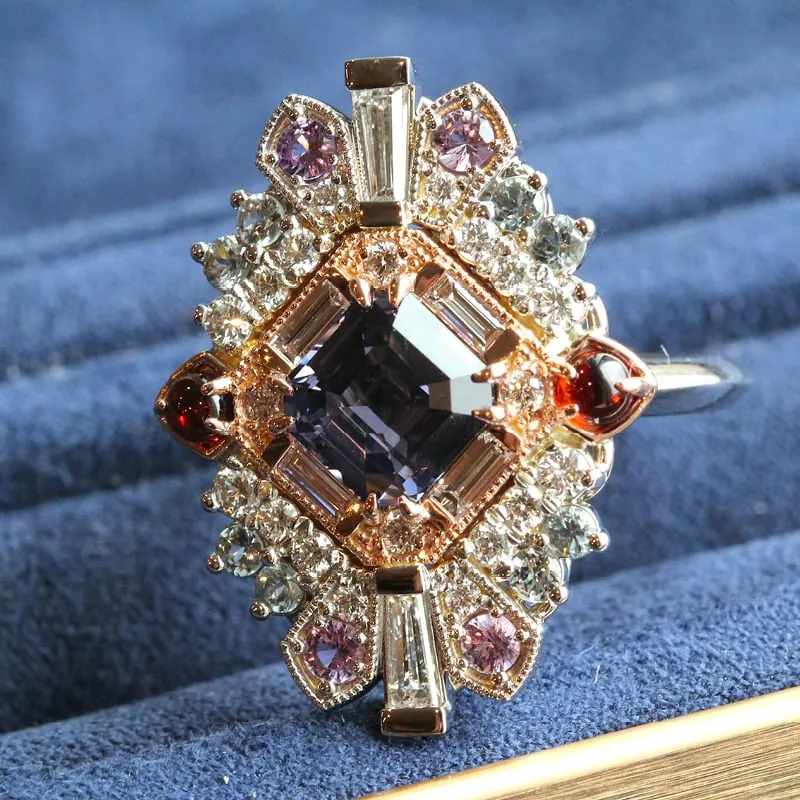 Custom statement ring with a dark center gemstone surrounded by colorful accent stones