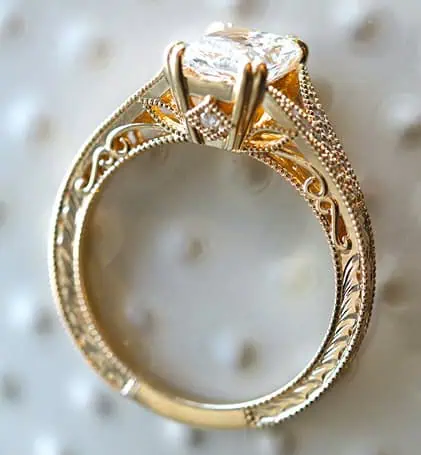 Gold engagement ring with intricate filigree and engraved details