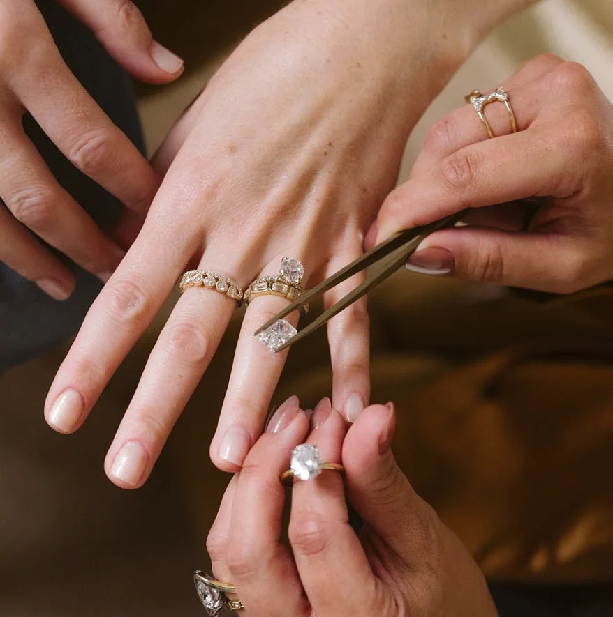 Jewelry designer helping a client try on rings during a consultation