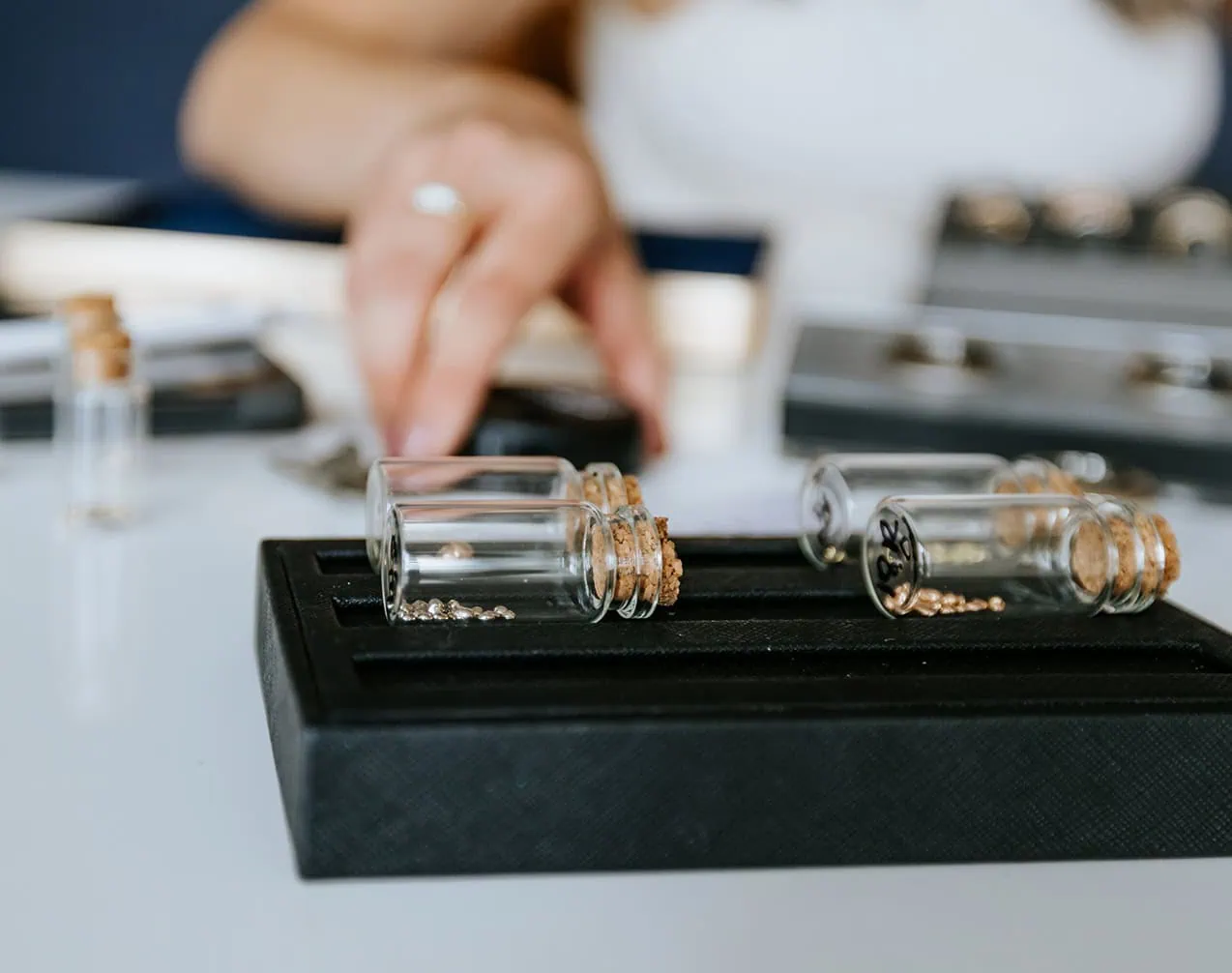 Small bottles of loose gemstones used for selecting stones during a jewelry consultation