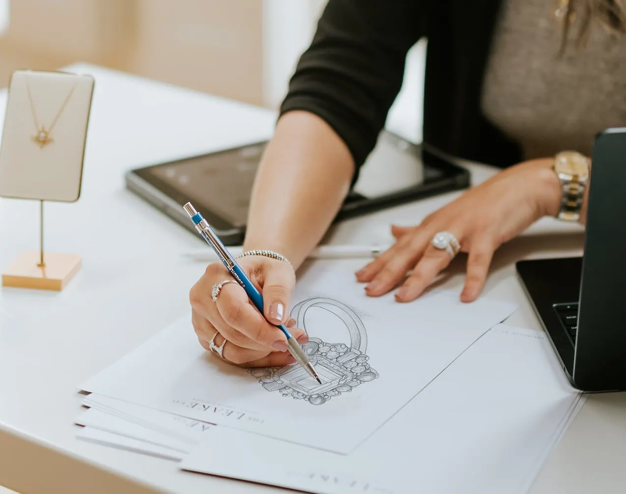 Jewelry designer sketching a custom ring design during the gemstone replacement planning process