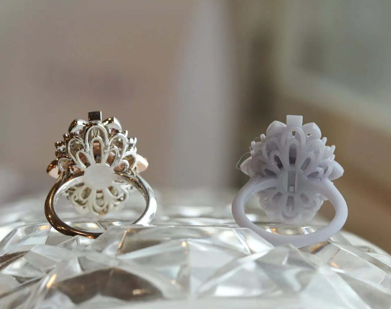 Gold ring setting beside a white 3D printed model