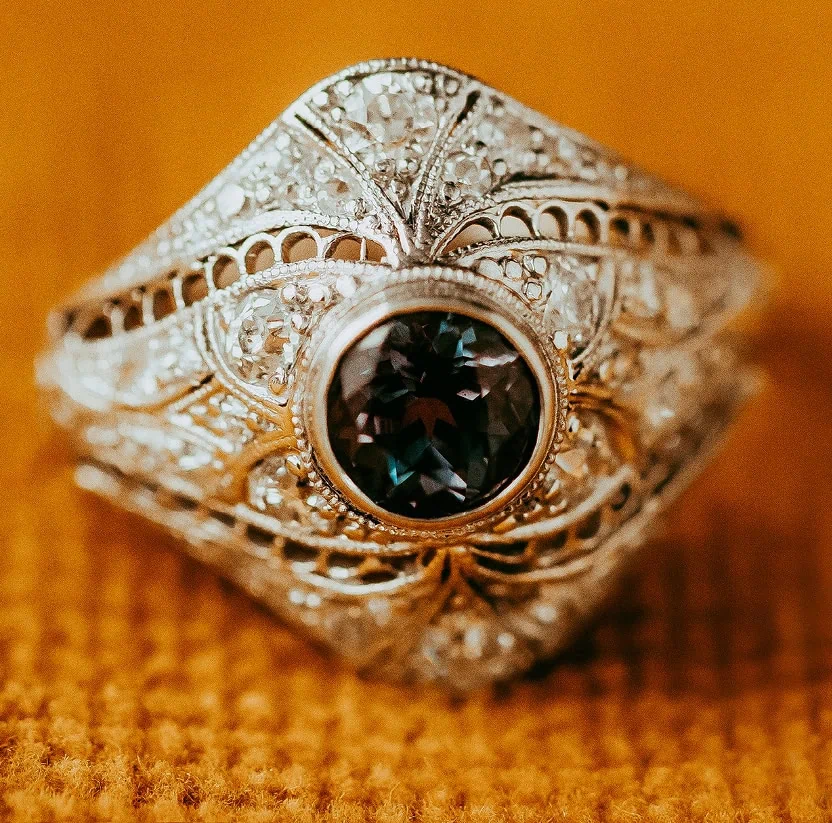 Vintage-style ring with intricate filigree and a dark center gemstone