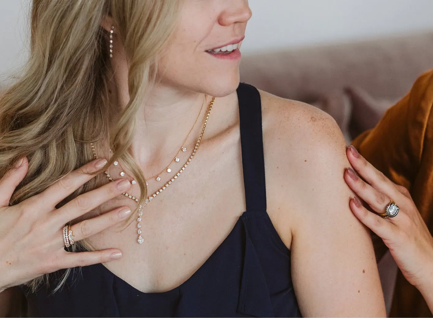 Woman wearing layered diamond necklaces during a jewelry consultation