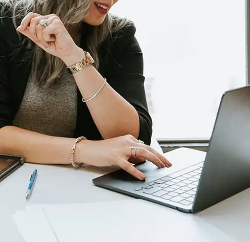Jewelry designer working on a laptop while managing custom jewelry design projects